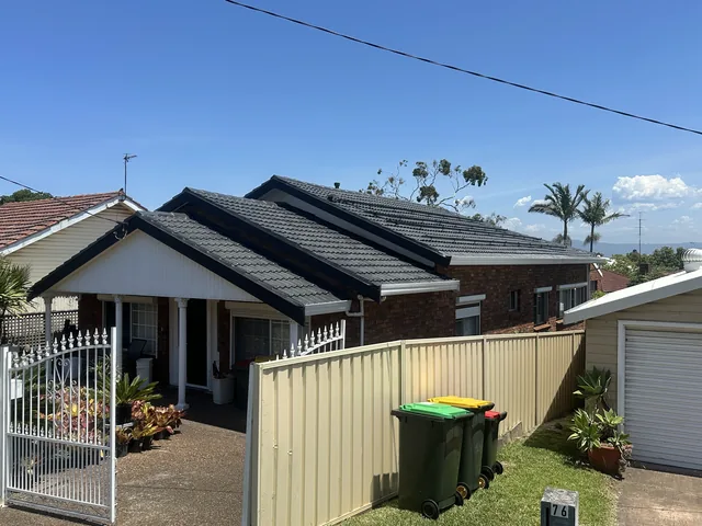The same house with a dark charcoal tile roof, Monument, after restoration.