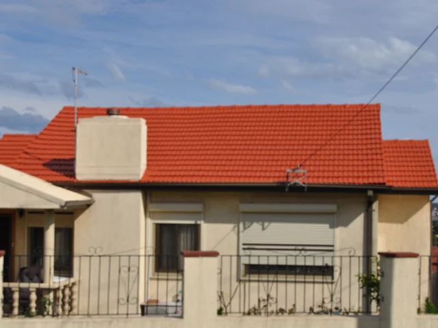 Cream rendered house with a freshly restored terracotta tile roof.